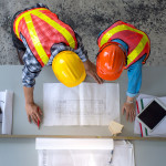 Top view of group of engineering team is meeting, planning construction work,looking paper plans at construction site,overhead view